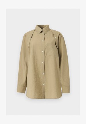 Chemise beige à manches longues avec boutons, col pointu, une poche poitrine et panneaux d'épaule à boutons-pression sur fond blanc.