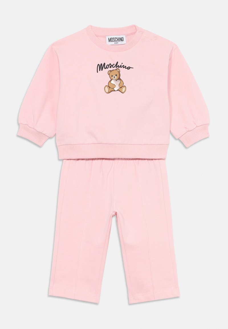 Rožinė medvilninė kūdikių apranga, kurioje yra megztinis su apvaliu kaklu ir teddy bears grafika bei derančios leginsai. Viršus turi raukinėtas rankoves ir apačią.