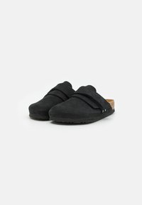 Schwarze Slipper mit strukturiertem Obermaterial, breitem Riemen über dem Fuß, Korkfußbett und flexibler Gummisohle. Mit abgerundeter Zehenpartie.