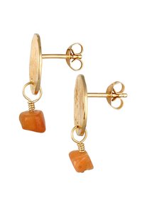 Des boucles d'oreilles en métal doré présentent un disque rond texturé avec une petite pierre orange suspendue en dessous. Le design comprend un accent en fil et ressort.