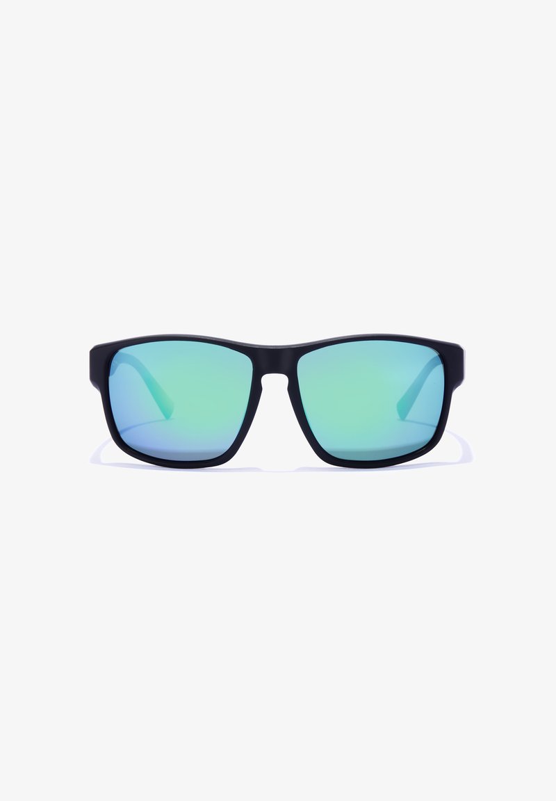 Mustade raamiga prillid, millel on ristkülikukujulised sinakas-rohelised läätsed, kuvatud otse esiplaanil valgel taustal.