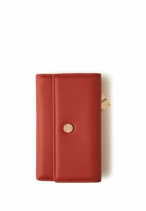Portafoglio compatto in pelle rossa con bottone a pressione circolare dorato e una piccola targhetta dorata sul lato su sfondo bianco.