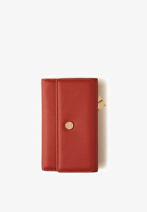 Portafoglio compatto in pelle rossa con bottone a pressione circolare dorato e una piccola targhetta dorata sul lato su sfondo bianco.