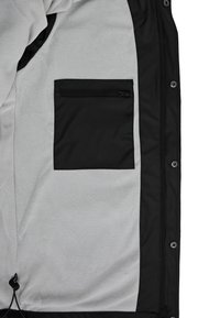 Black jacket interior made of gray fleece with a zippered black pocket on the left. Features a drawstring at the bottom hem.