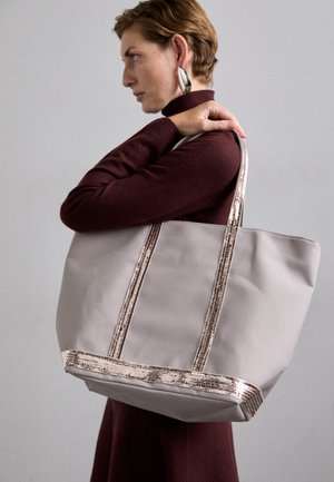 Siva torba s metalik ružičastim zlatnim detaljima i trakama. Ima jednostavan, prostran dizajn i glatku teksturu.