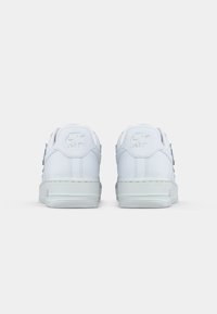 Par med hvite Nike Air joggesko vist fra baksiden på en enkel hvit bakgrunn.