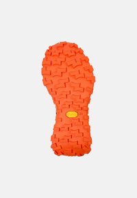 Vibram podešev v jasně oranžové barvě s texturovaným, agresivním vzorem pro trakci. Obsahuje žluté logo a označení velikosti 38.