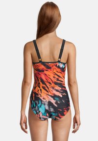 Maillot de bain une pièce avec un motif abstrait multicolore en orange, noir et turquoise, bretelles ajustables et coupe élégante.