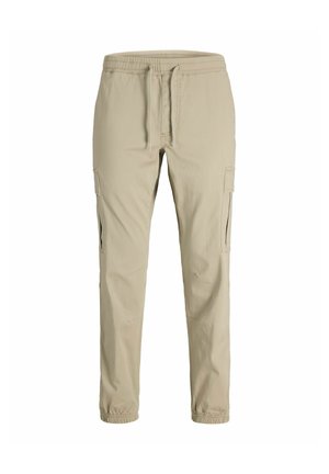 Pantalon cargo beige slim fit avec taille élastique, cordon de serrage, poches latérales et poignets élastiques.