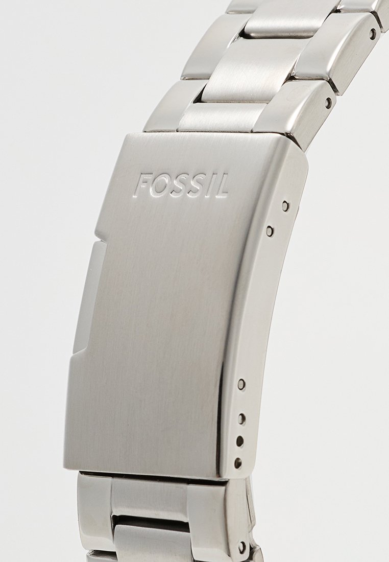 Metallarmband mit gebürsteter Silberoberfläche, glatter Oberfläche, rechteckiger Schnalle und eingraviertem "FOSSIL"-Logo.