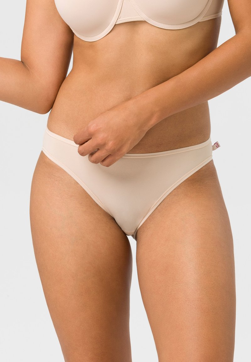 Beige Hipster-Slips aus weichem, glattem Material mit einem niedrigen Bund. Minimale Nähte und ein kleines Markenetikett an der Seite.