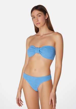 Blå bikini i texturerad tyg, med en bandeau-top försedd med en central rosett och matchande låga bottoms.