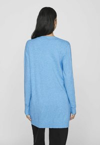 Hele sinine pika varrukaga kudumissweater, ümmarguse kaelusega, sooniku lõpetuste ja äärega, vabalt langev, valmistatud pehmest ja tekstureeritud lõngast.