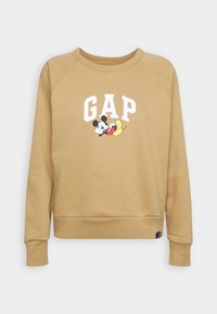 Złoto-brązowy sweatshirt z okrągłym dekoltem, rękawami raglanowymi oraz nadrukowanym logo "GAP" z Mikiem Mausiem i bananami. Miękka struktura.