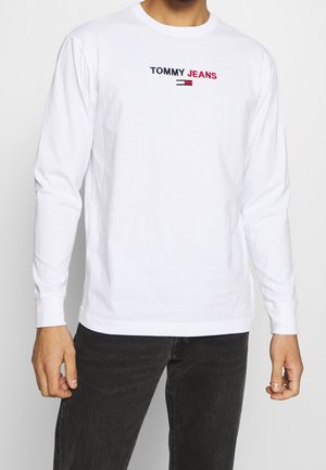 Wit, langärmelig T-shirt van katoen, met het geborduurde "TOMMY JEANS" logo in zwart en rood op de borst. Eenvoudige ronde halslijn.