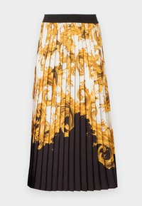 Falda midi plisada con cintura negra, con base blanca y patrones ornamentales de remolinos barrocos dorados que se desvanecen en negro sólido en el dobladillo.