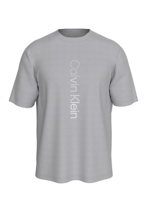 Camiseta gris claro de manga corta con el logo vertical en blanco de "Calvin Klein" impreso en el centro frontal.
