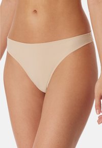 Beżowe dno bikini o gładkiej fakturze, niskim kroju i cienkich bocznych paskach. Posiada minimalne szwy i klasyczny krój.