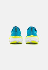 Baskets de course bleues et jaune néon avec un dessus texturé, un col rembourré et une semelle blanche. Présente un accent réfléchissant sur le talon.