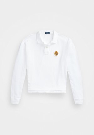 Witte lange mouw cropped polo met kraag, voorzien van een gouden geborduurd wapen op de linkerkant van de borst en een rechte zoom.