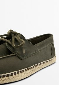 Grøn læder espadrille sko med en tekstureret overflade, der har en matchende snøre, broderede detaljer og en vævet jute-sål.