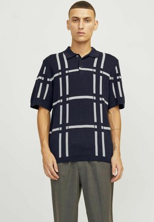Navy polo shirt with short sleeves, features a light gray grid pattern, ribbed collar, and four-button placket. Smooth knit fabric.