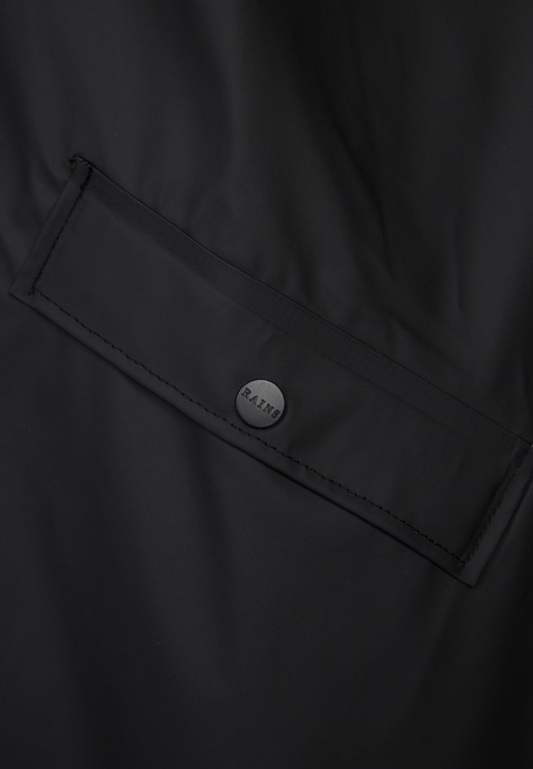 Giacca nera impermeabile con tasca con zip e chiusura a scatto, texture liscia e dettaglio di branding discreto.