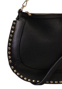 Sac à main en cuir noir avec une finition texturée, présentant des clous dorés sur le côté, une fermeture zippée et une bandoulière ajustable.