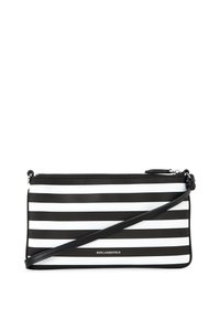 Sac bandoulière à rayures noir et blanc avec fermeture éclair, doté d'une texture lisse et d'une bandoulière réglable. Détail du logo à l'avant.