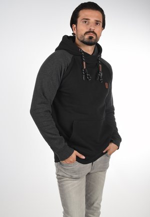 Zwarte hoodie met grijze raglanmouwen, voorzien van een voorkant zak, verstelbare koordjes en een klein logo-opdruk. Zachte stoftextuur.
