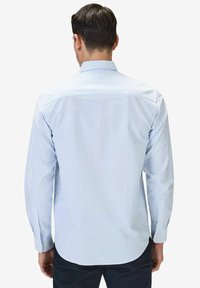 Vaaleansininen ja valkoinen raidallinen pitkähihainen paita, jossa on napillinen kaulus, kapea malli ja napilla kiinnitettävät hihansuut.