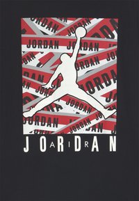 Silhouette di un giocatore di basket che salta con la palla, su strisce sovrapposte rosse, bianche e grigie che mostrano la parola "JORDAN" ripetuta.