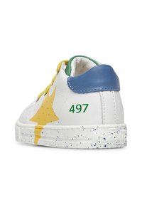 Sneaker bianca in pelle con design a stella gialla, lacci verdi, cappuccio del tallone blu e suola bianca maculata. Numero "497" stampato sul lato.