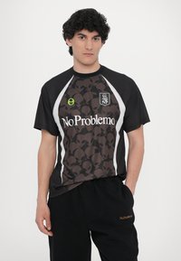 T-shirt preta de manga curta com um padrão de crânio alienígena escuro, painéis laterais brancos e "No Problemo" impresso em branco no peito.