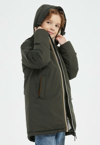 Veste noire rembourrée avec capuche, dotée d'une fermeture éclair sur le devant et de deux poches latérales avec des accents orange. Texture douce, design mi-long.