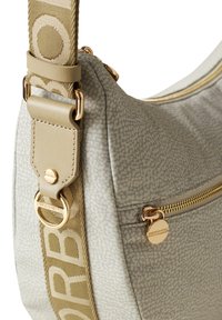 Sac bandoulière gris à motif avec un tissu texturé, quincaillerie dorée et une bandoulière ornée d'un logo. Dispose d'une poche zippée extérieure et d'un design épuré.