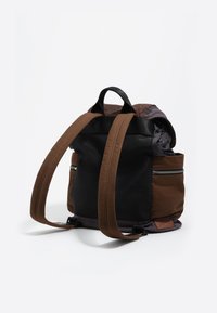 Rjav in črn nahrbtnik z teksturirano površino, najlonski material, dvo-barvna zasnova, nastavljive naramnice in zunanji žep na zadrgo.
