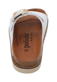 Weiße Sandalen mit offener Zehenpartie und goldener Schnalle, Korkfußbett, braunem Lederfußbett und strukturiertem Gummilaufsohle. Der Markenname "Palado" ist im Inneren sichtbar.