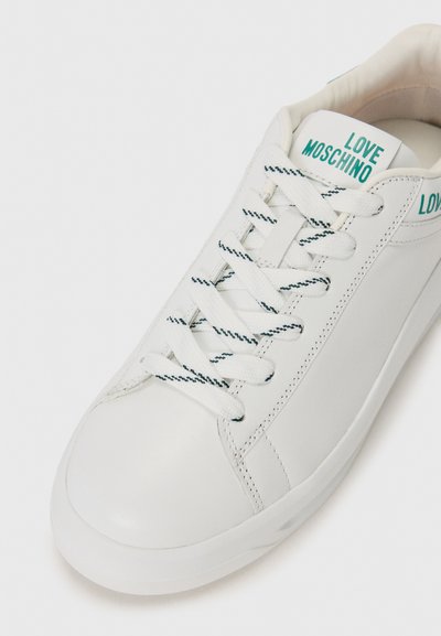 White leather sneaker with textured sides, round toe, and flat laces. Features blue "LOVE MOSCHINO" branding on the heel and tongue.