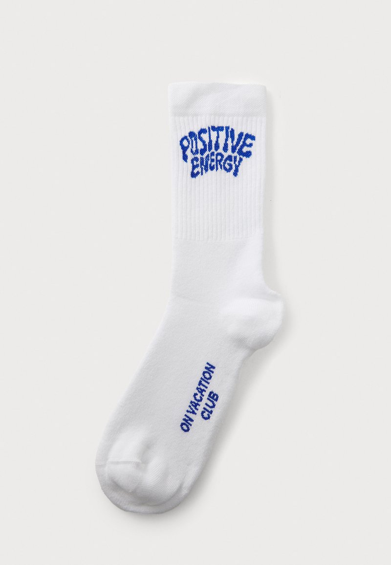 White crew sock made of cotton blend, featuring blue embroidered text "POSITIVE ENERGY" on the front and "ON VACATION CLUB" on the side.