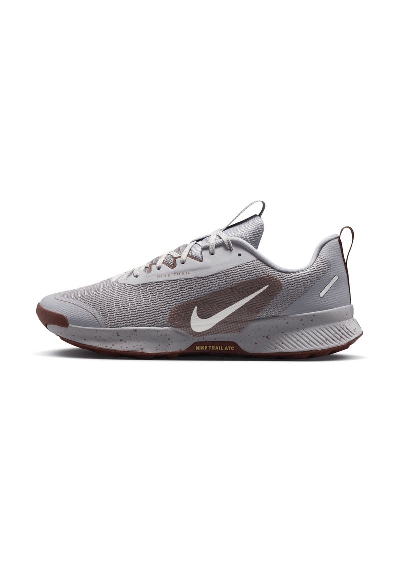 Gray and brown Nike trail running shoe with white swoosh logo, textured knit upper, laces, and speckled sole, side view on white background.