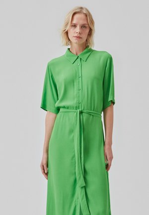 Robe chemise verte en tissu doux avec un col, un devant à boutons, des manches courtes et une ceinture à nouer à la taille.
