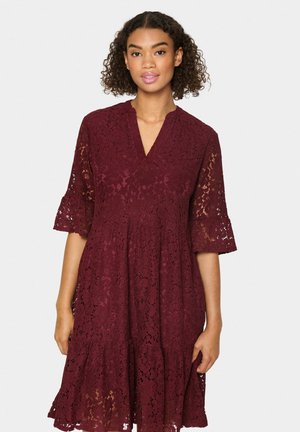 Burgundy spetsklänning med korta utsvängda ärmar, V-ringning och en lagerdelad nederdel, med blommönster och en texturerad yta.