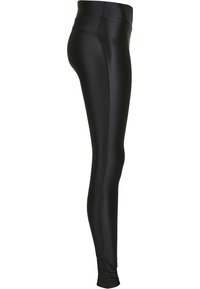 Leggings neri realizzati in un tessuto liscio e elasticizzato, con una vita alta e un design aderente che si restringe alla caviglia.
