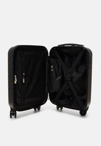 Valigia rigida nera con accenti dorati, tasca in rete interna, cinghie incrociate e quattro ruote. Presenta una chiusura zip e un esterno testurizzato.