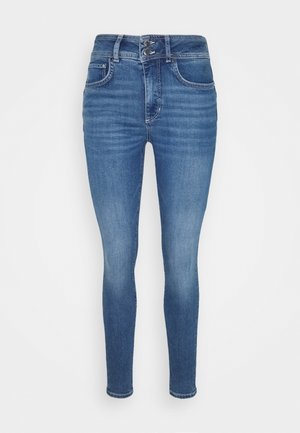 Jeans ajustados en denim de lavado medio, con una cintura alta, dos bolsillos delanteros y un cierre de botón con cremallera. Detalle de decoloración sutil.