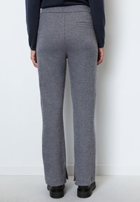 Grijs en wit geruite broek met een rechtbenig ontwerp, voorzien van een zijsplit aan de onderkant en een achterzak. Gemaakt van een gestructureerde stof.