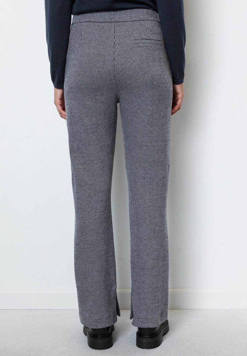 Grijs en wit geruite broek met een rechtbenig ontwerp, voorzien van een zijsplit aan de onderkant en een achterzak. Gemaakt van een gestructureerde stof.