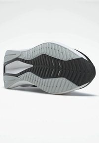 Suela de zapato con un diseño de patrón de banda ondulada, con una sección de goma negra y áreas texturizadas en gris, destacando un diseño contrastante y agarre.
