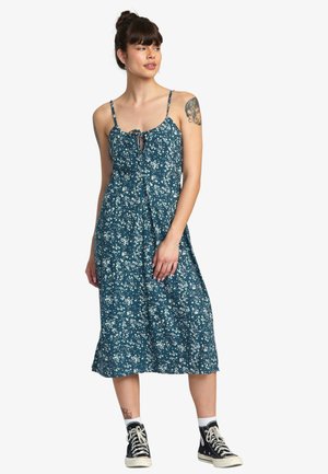 Floral midi dress in teal with spaghetti straps, button front, and tie detail. Made of lightweight fabric with a flowy design.